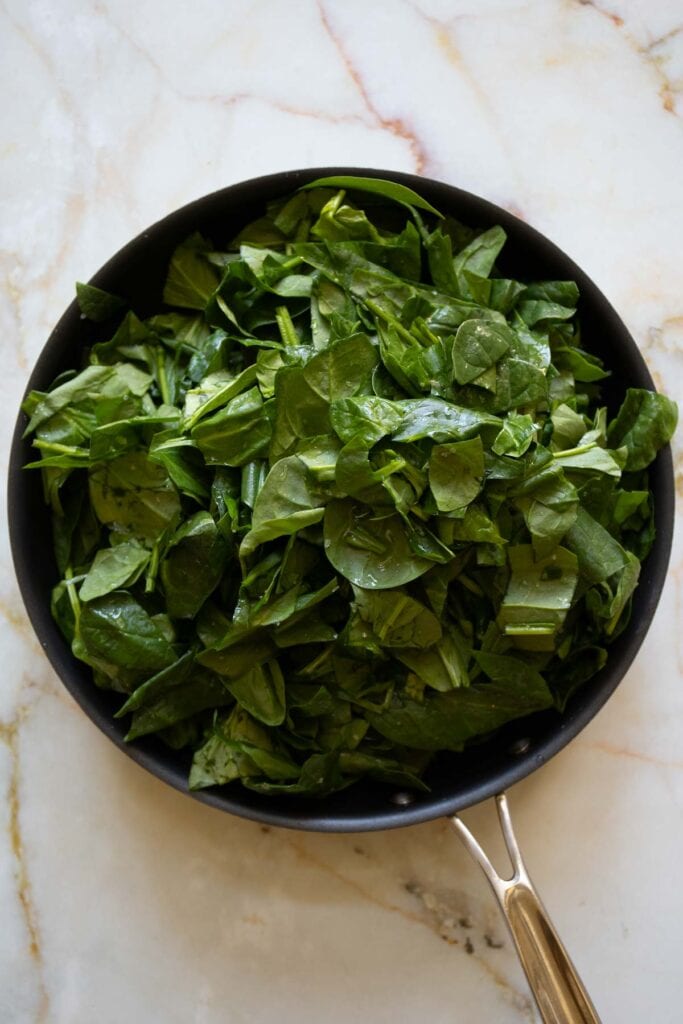 roughly chopped spinach in a pan