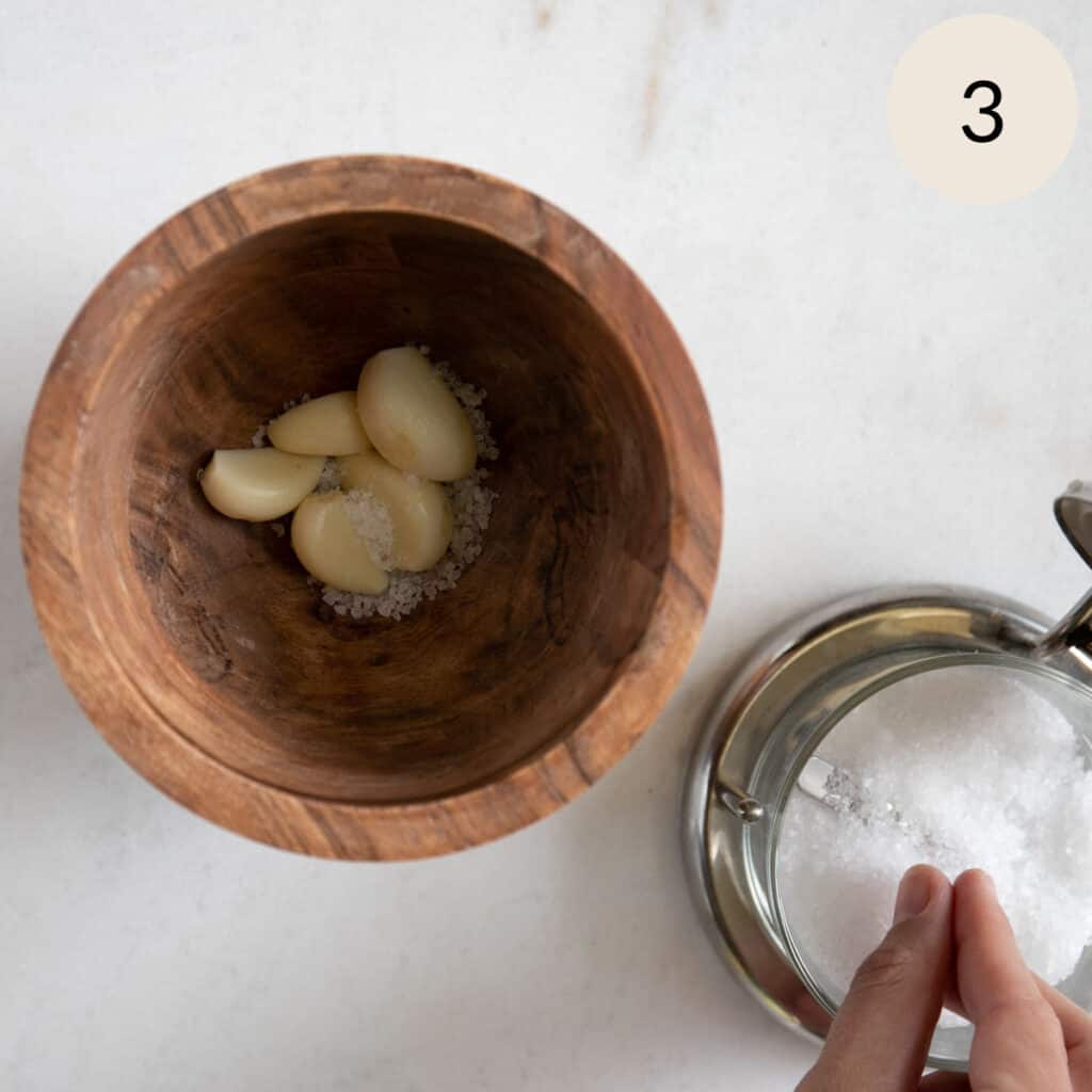 add some salt and garlic to a bowl