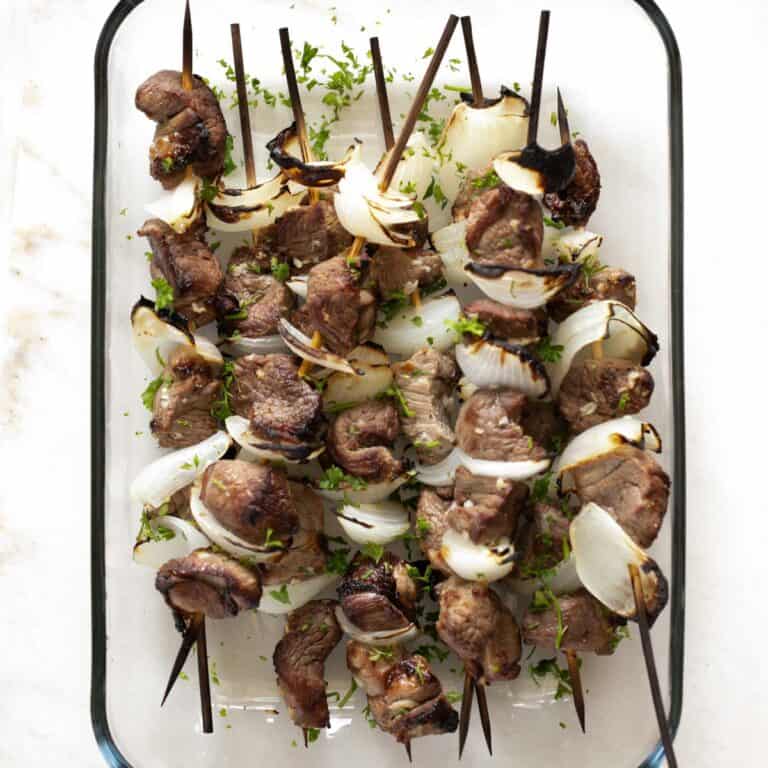 lamb kabob skewers in a glass container