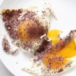 sumac eggs on a plate with the yolk runny