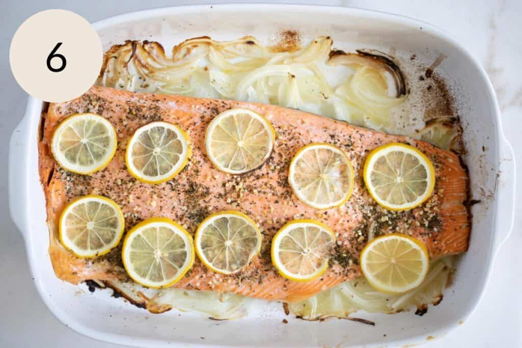 the trout fish after it's been baked in the oven over a bed of sliced onions