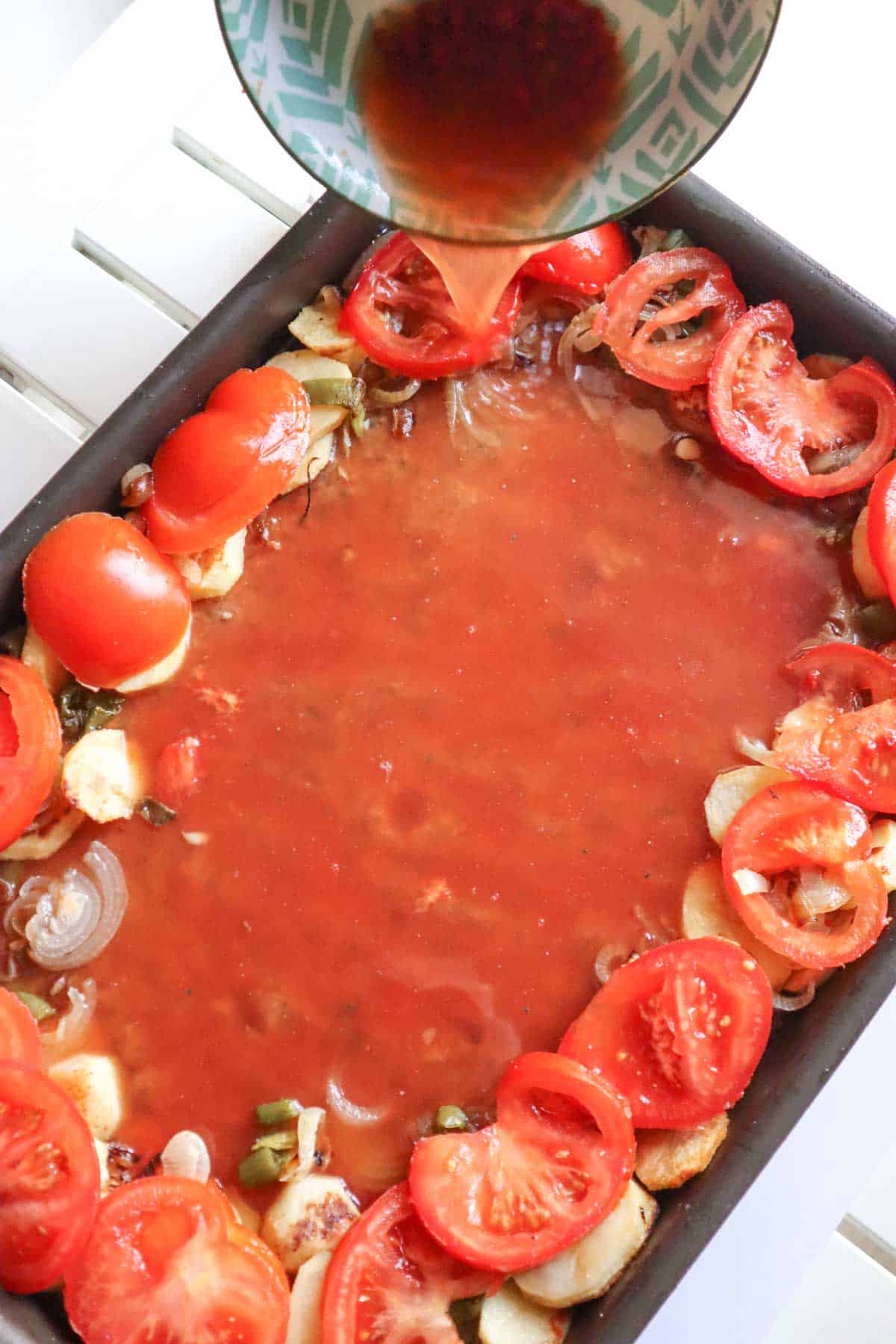 pouring the tomato sauce on the kafta minced meat