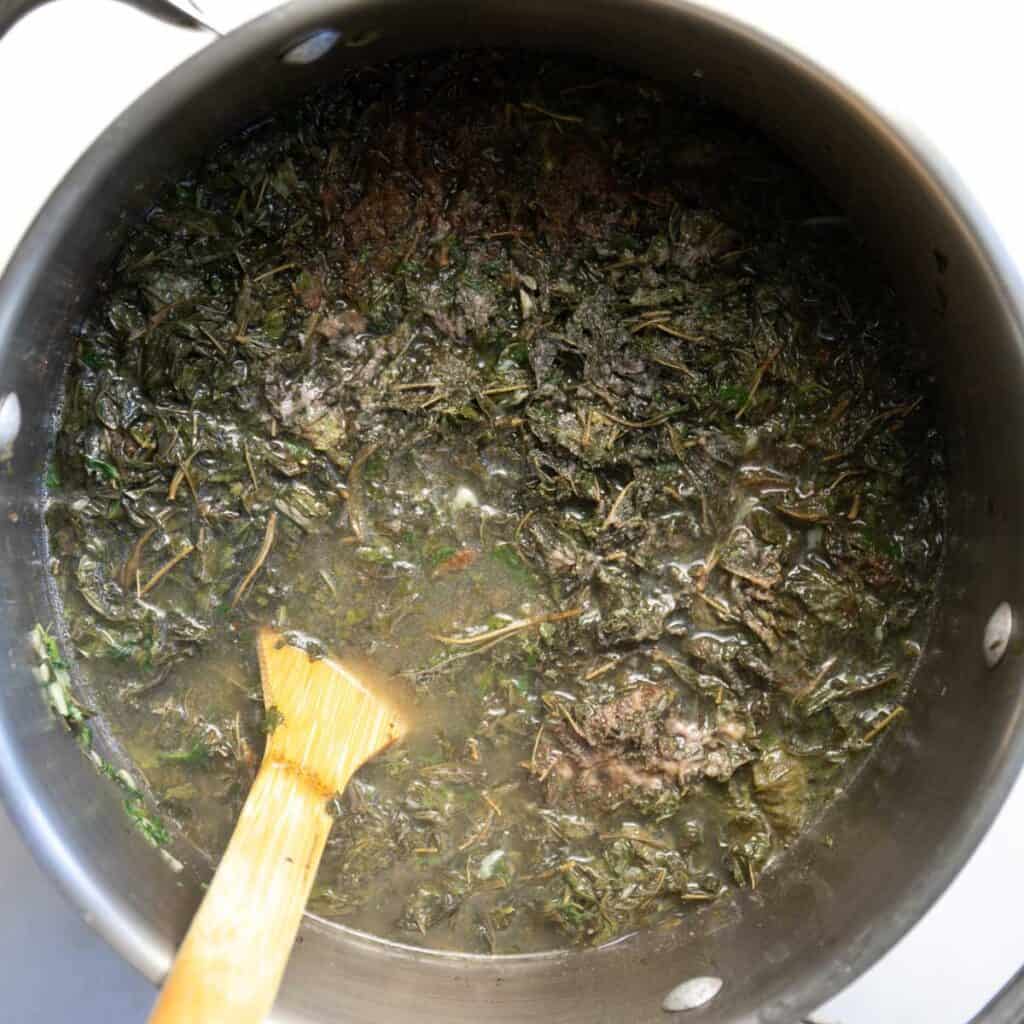 adding the homemade chicken broth to the mloukhieh