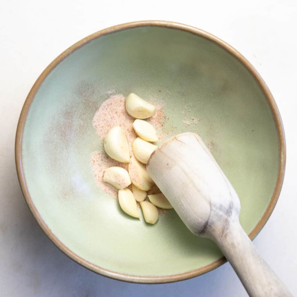 mashing garlic with salt