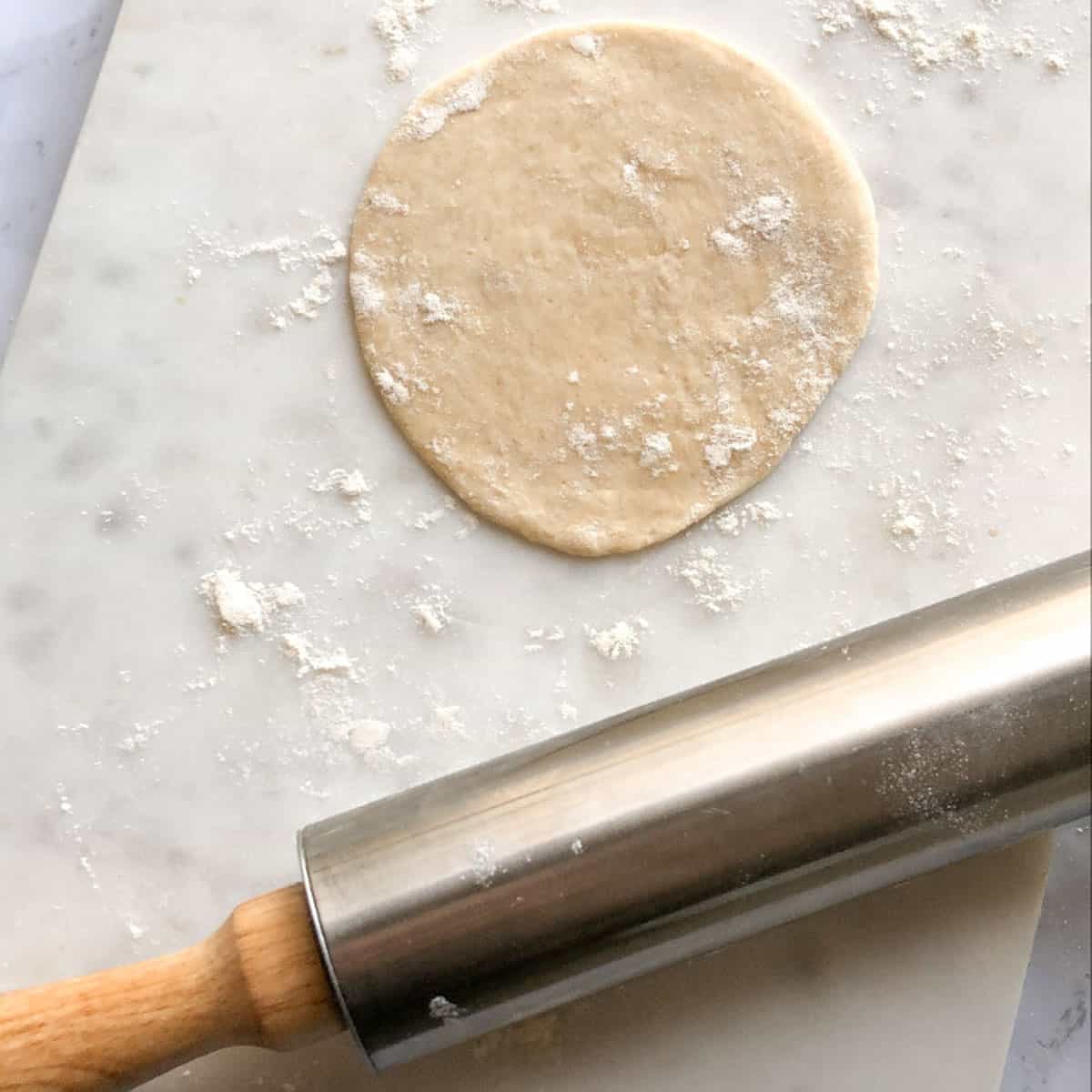 rolling the dough ball with a rolling pin
