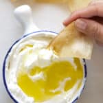 pita chips dipping into some labneh with olive oil