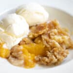 canned peach cobbler with cake mix and scoops of ice cream.