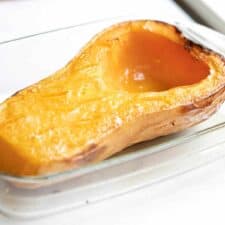 roasted butternut squash half in a baking dish.