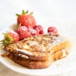 brioche french toast with berries, powdered sugar, and maple syrup.