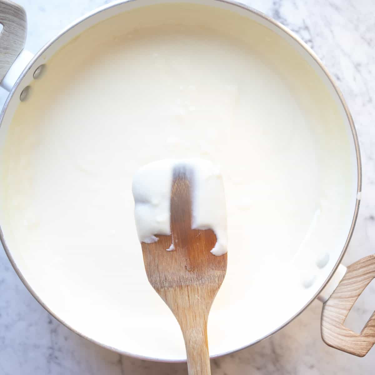 bechamel sauce coating a wooden spoon
