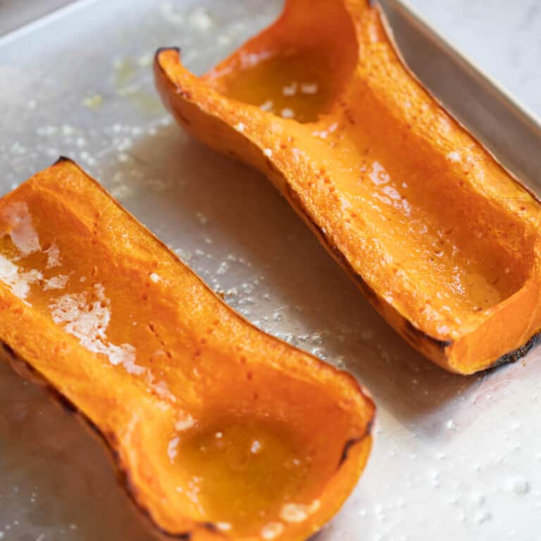 roasted butternut squash halves on a baking sheet