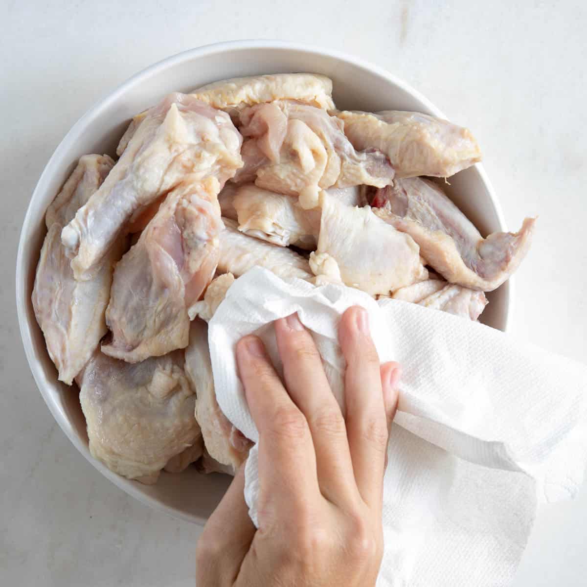 drying the chicken wings with a paper towel.