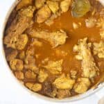 close up view of bengali chicken curry in a pot.