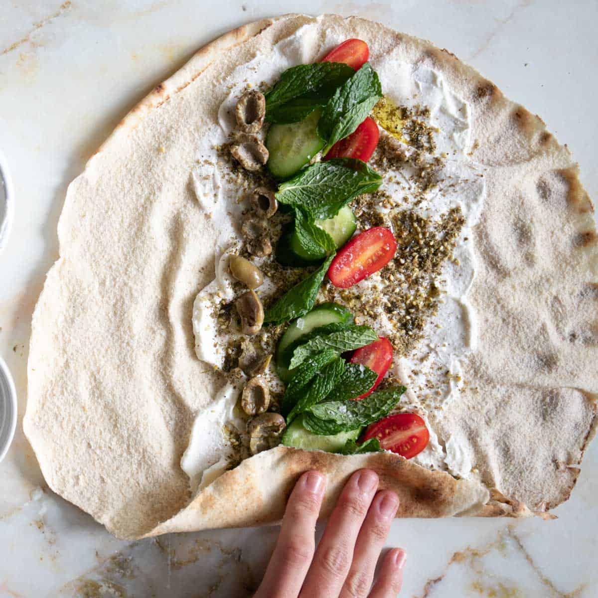 rolling the labneh pita sandwich like a burrito.