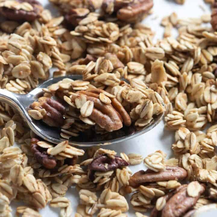 close up view of maple pecan granola on a spoon.
