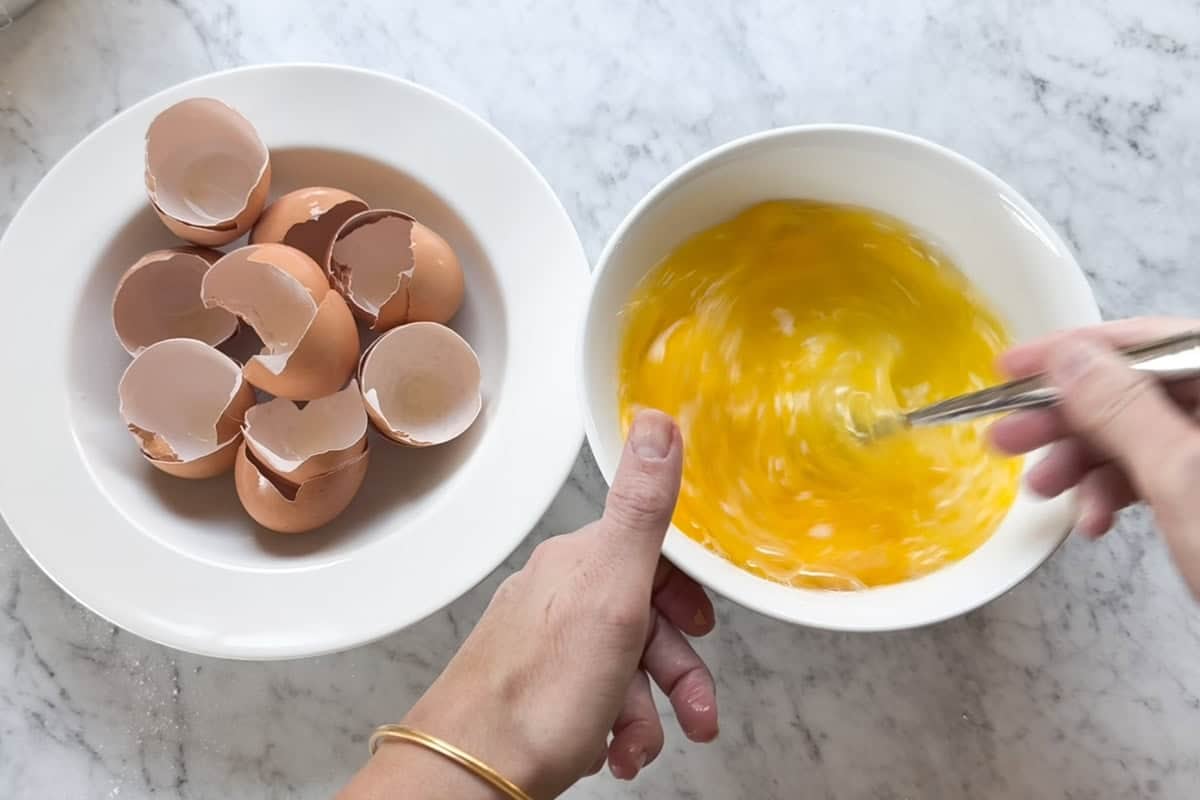 Mixing eggs in a bowl with a fork.