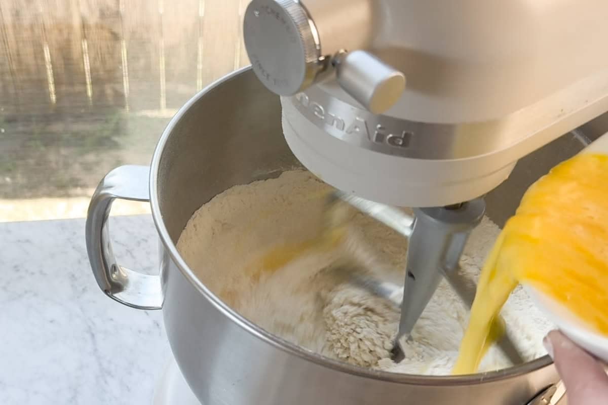 pouring the egg mixture into the flour.