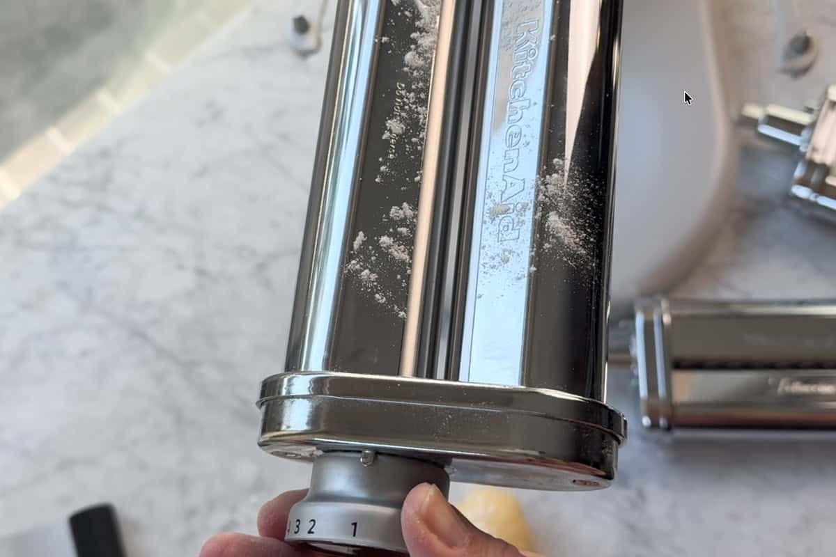 setting the pasta roller to the largest setting.