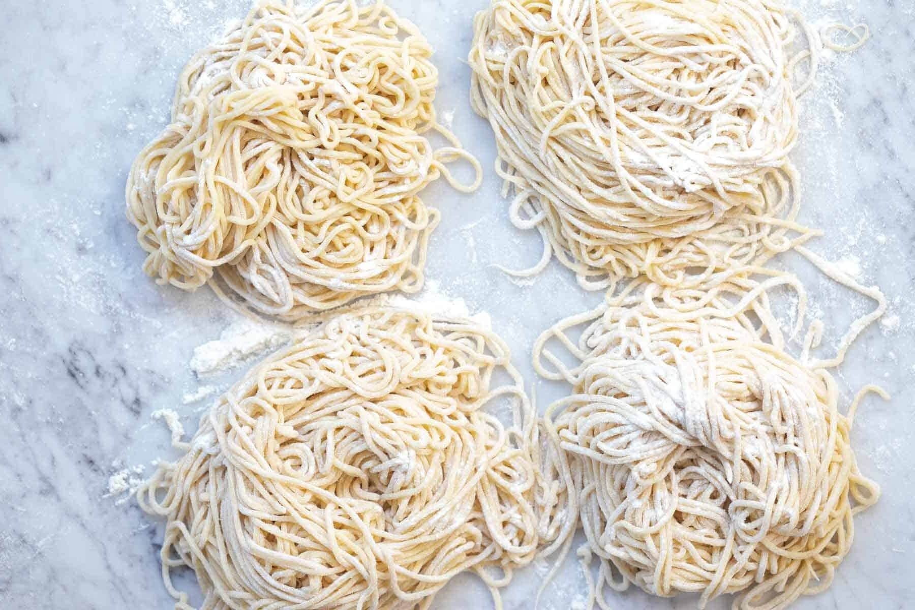 homemade spaghetti noodle nests dusted with flour.