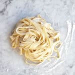homemade fettuccine noodles from scratch on a counter.