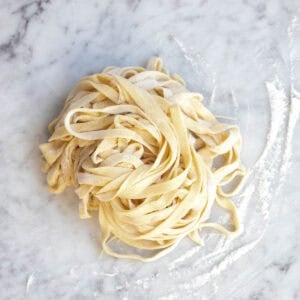 homemade fettuccine noodles from scratch on a counter.