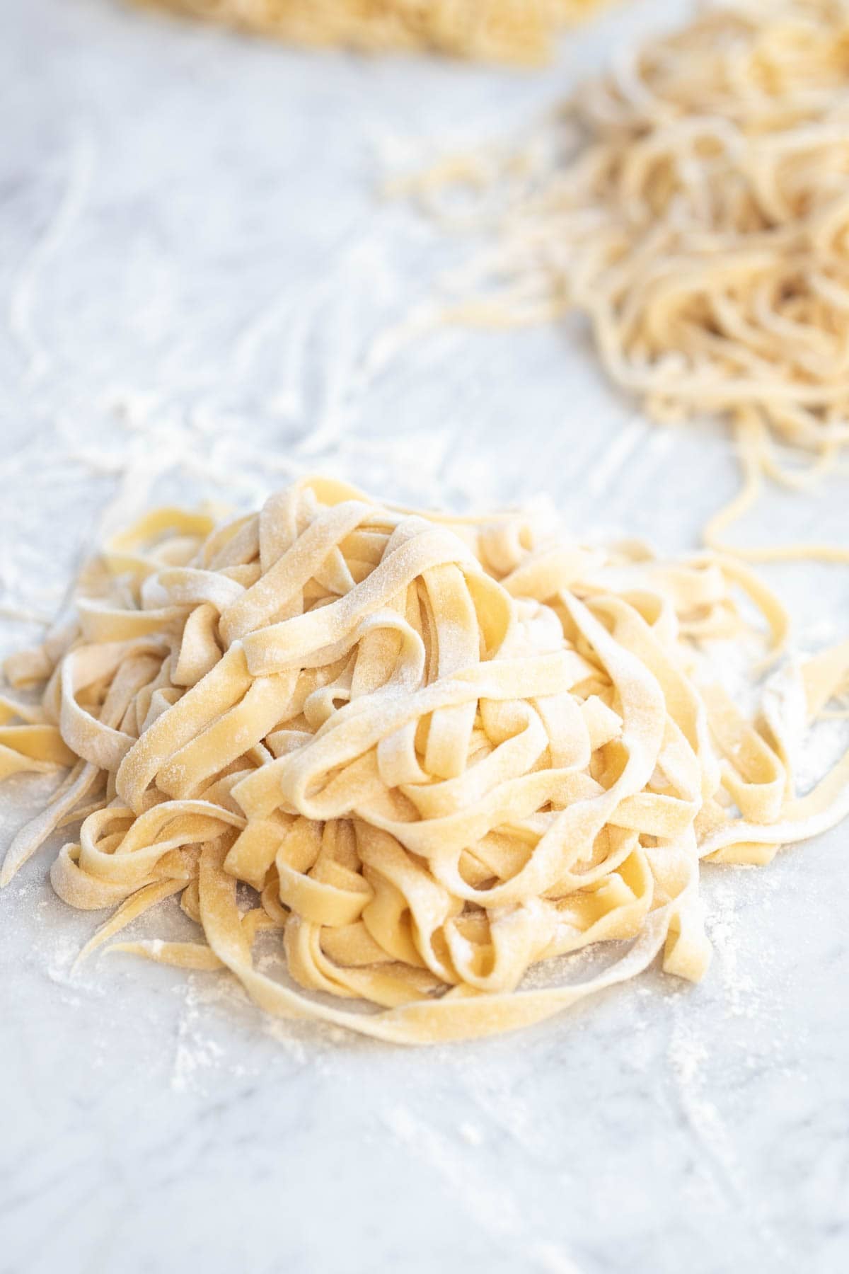 Homemade fettuccine noodles with flour dusted.
