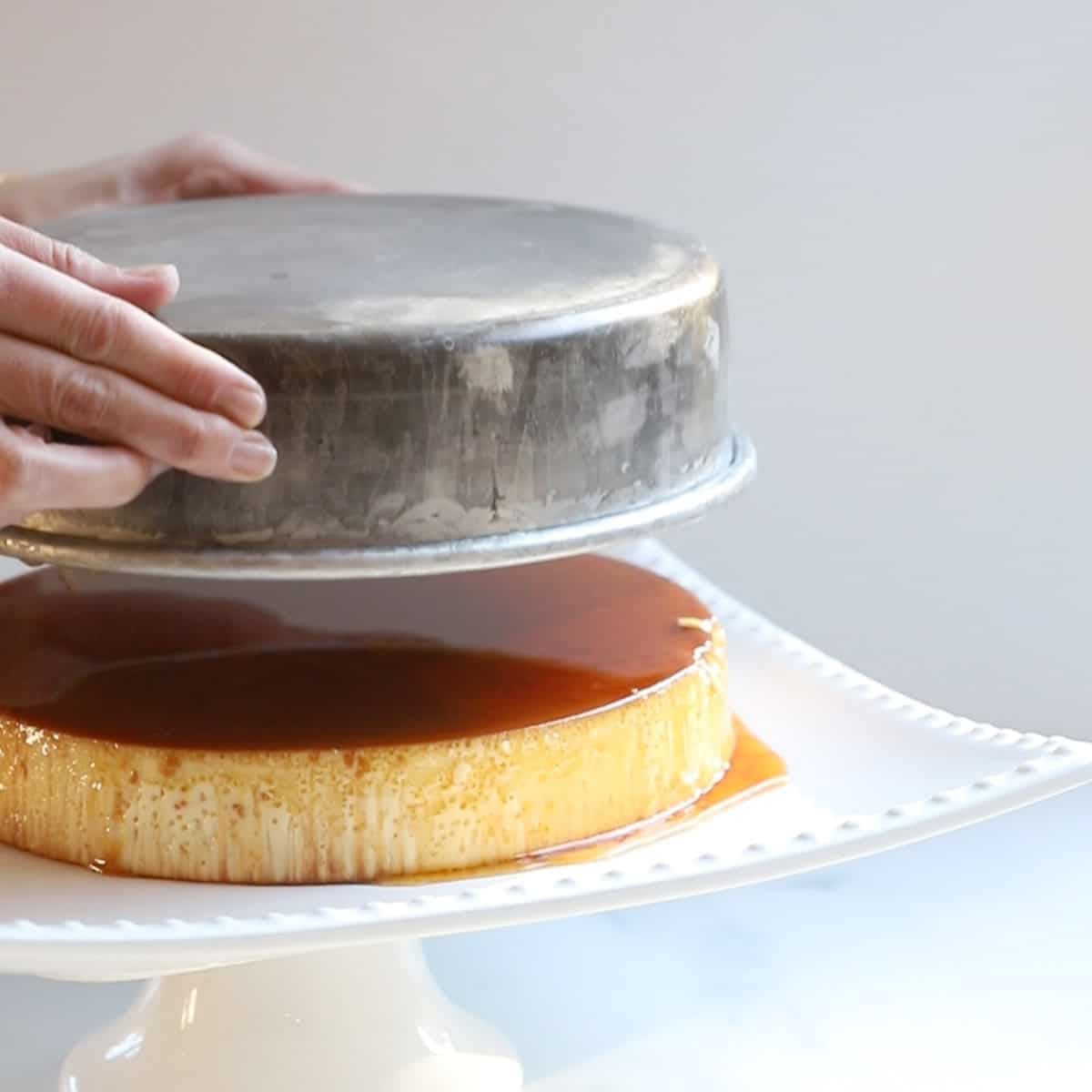 removing the cake pan from the caramel flan with condensed milk.