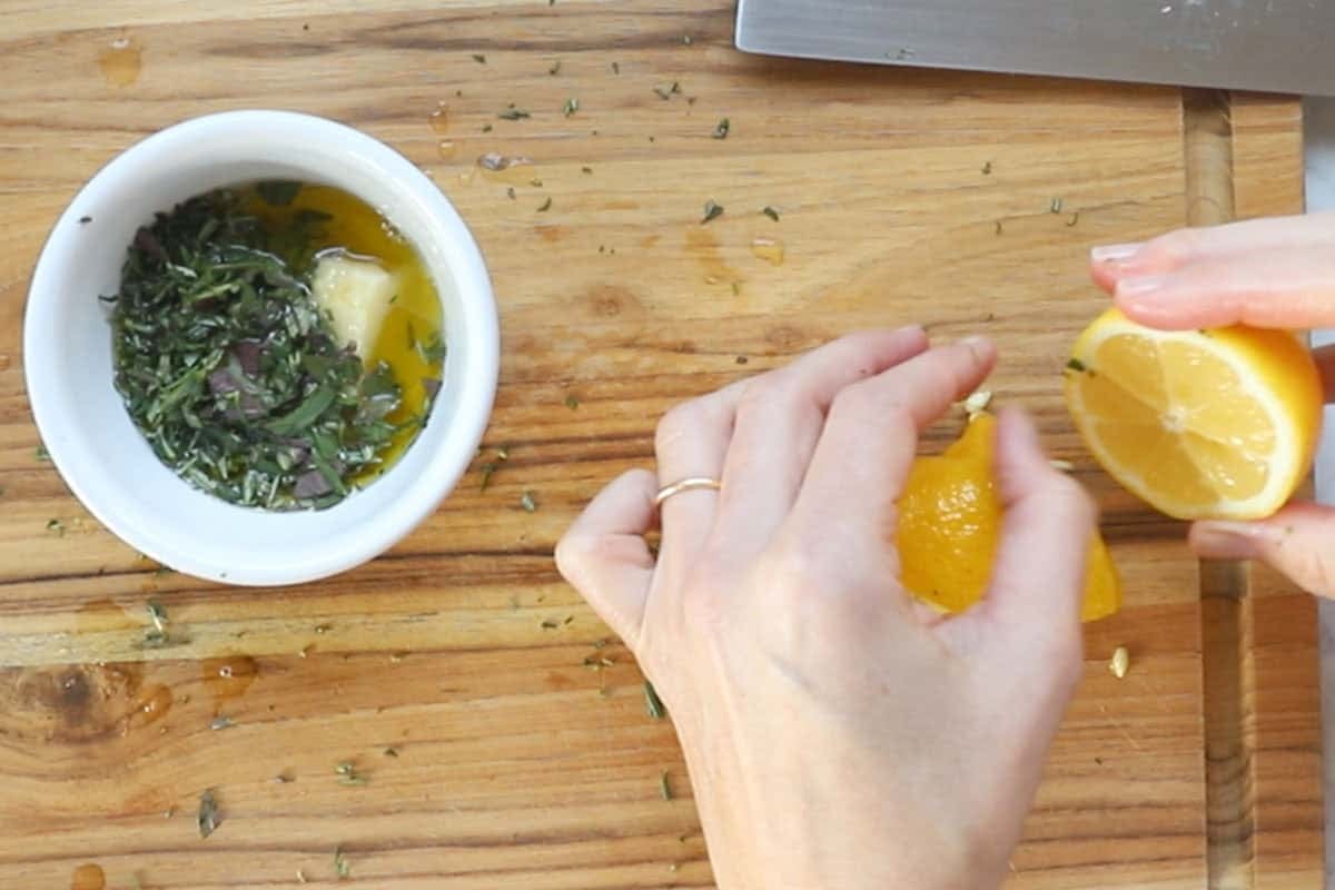 making the mediterranean marinade of fresh herbs, lemon juice, crushed garlic, and olive oil.