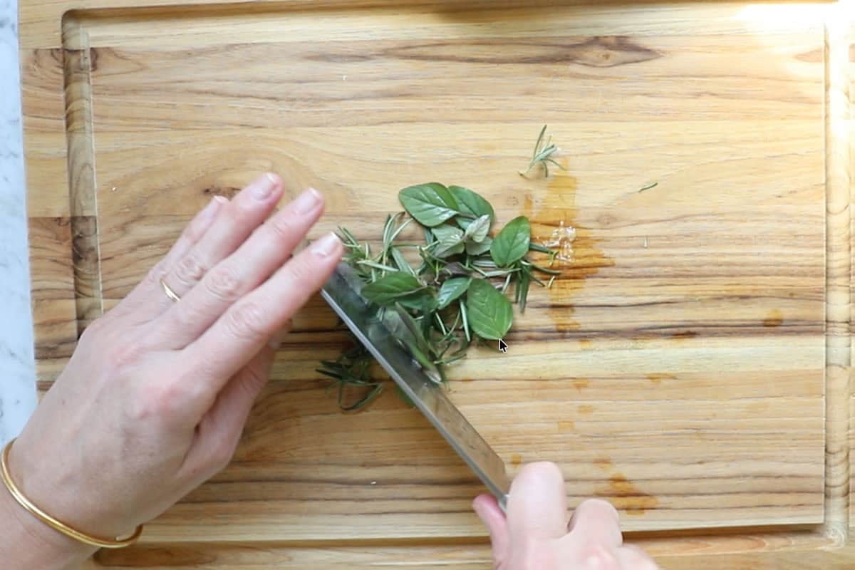 chopping fresh rosemary and fresh oregano