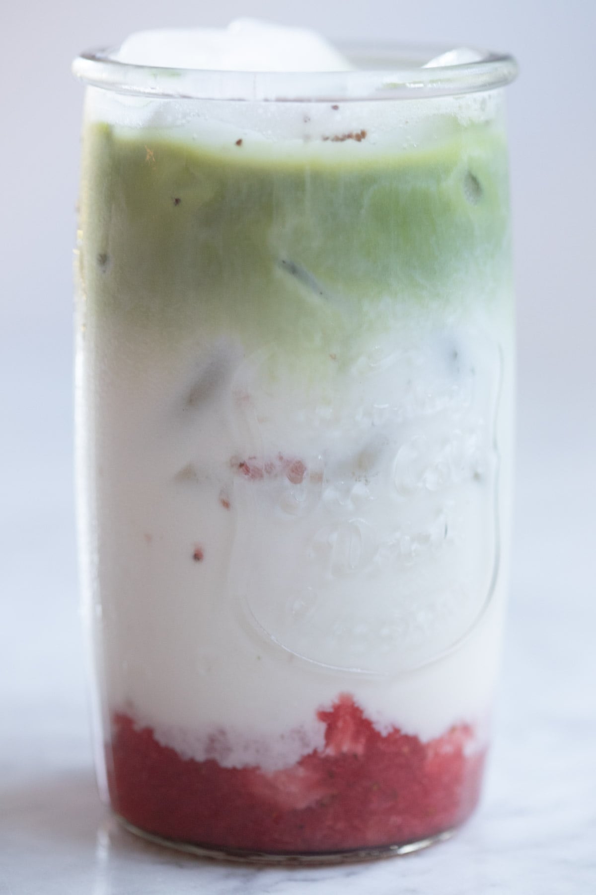 A refreshing layered fruit and yogurt beverage with vibrant colors in a tall glass.